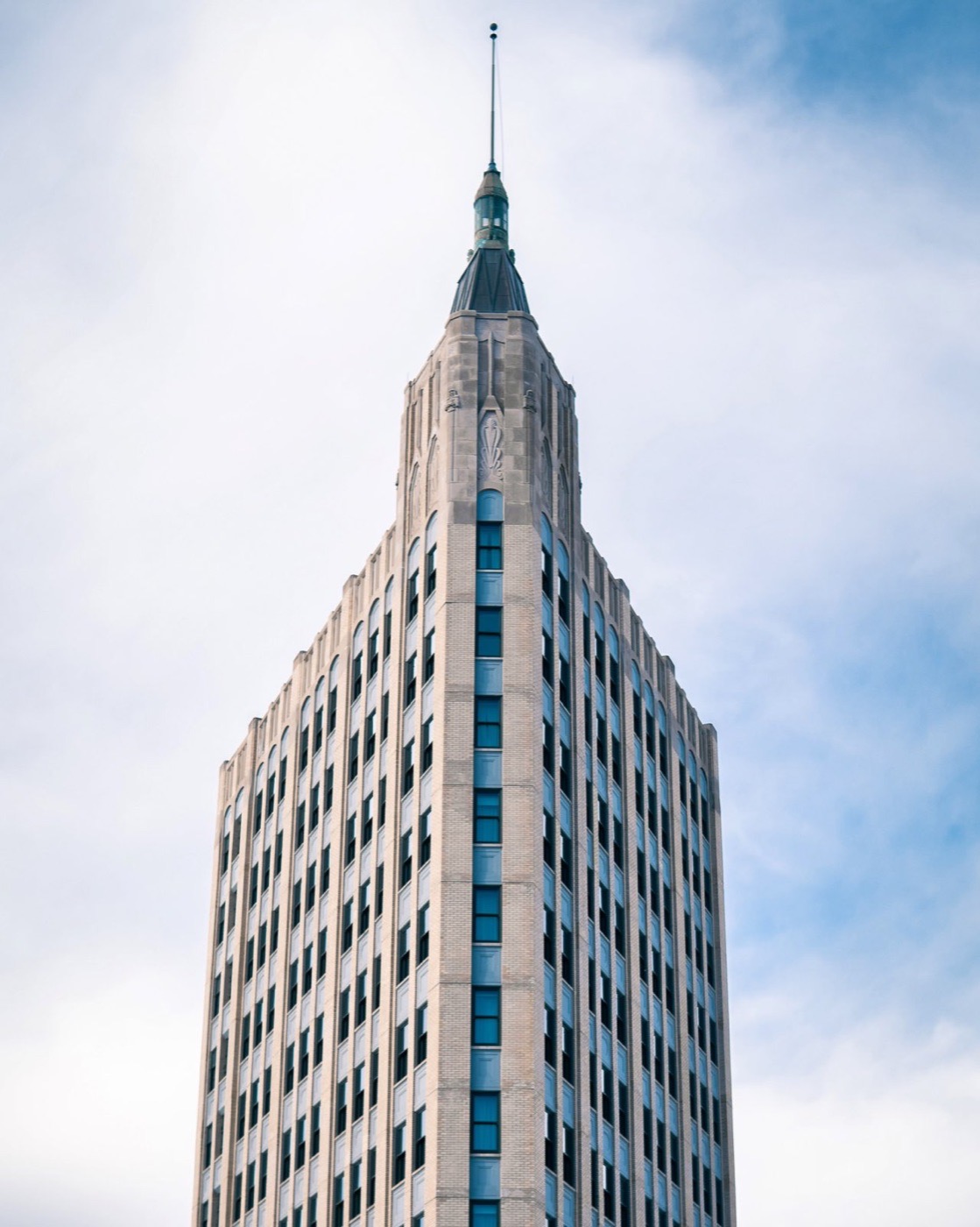 Tall art deco building photographed from below against a bright sky