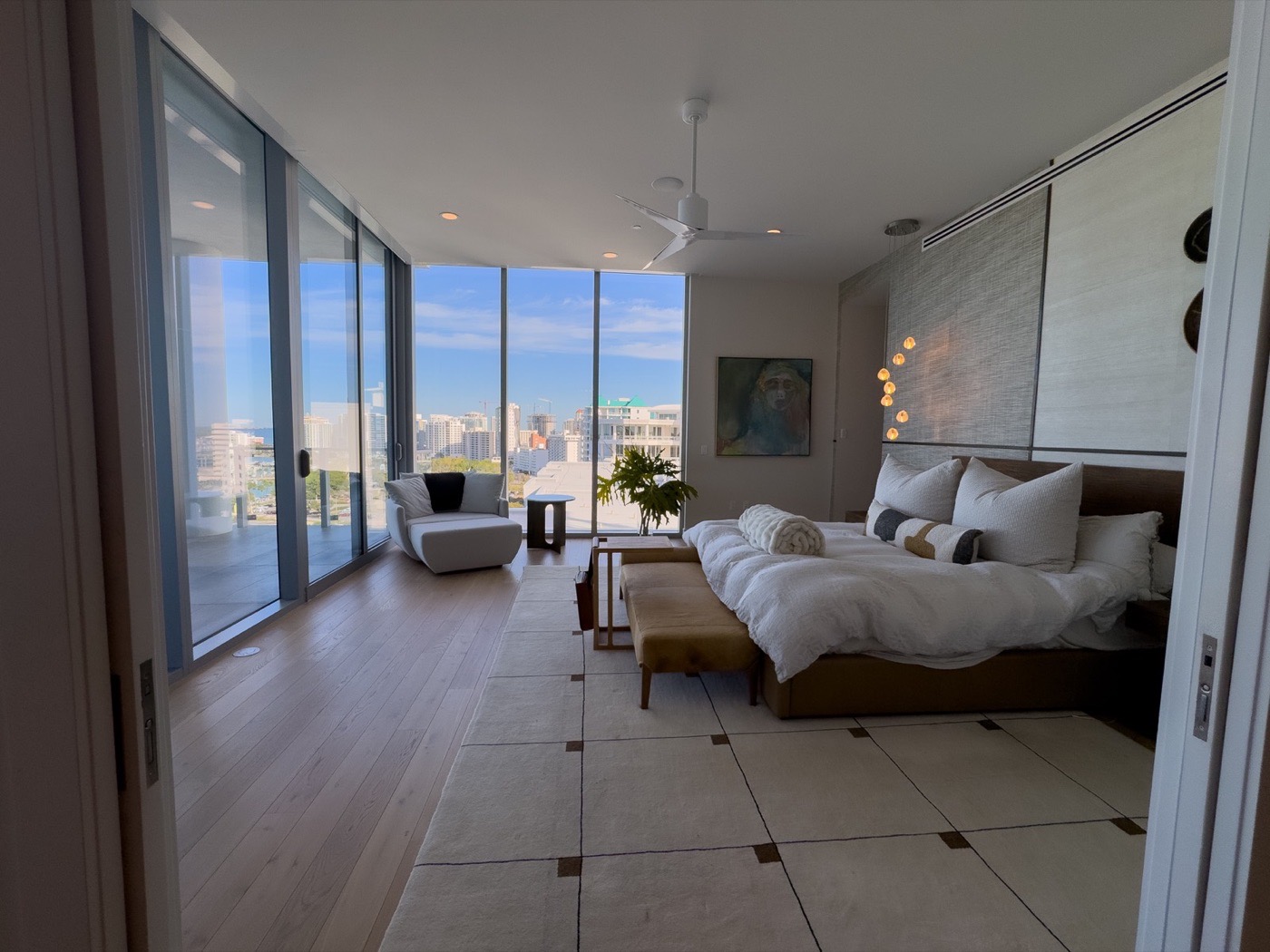 Bright bedroom with balcony doors and city view