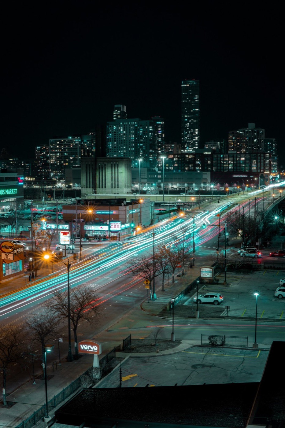 Night cityscape with long light trails running through the street below
