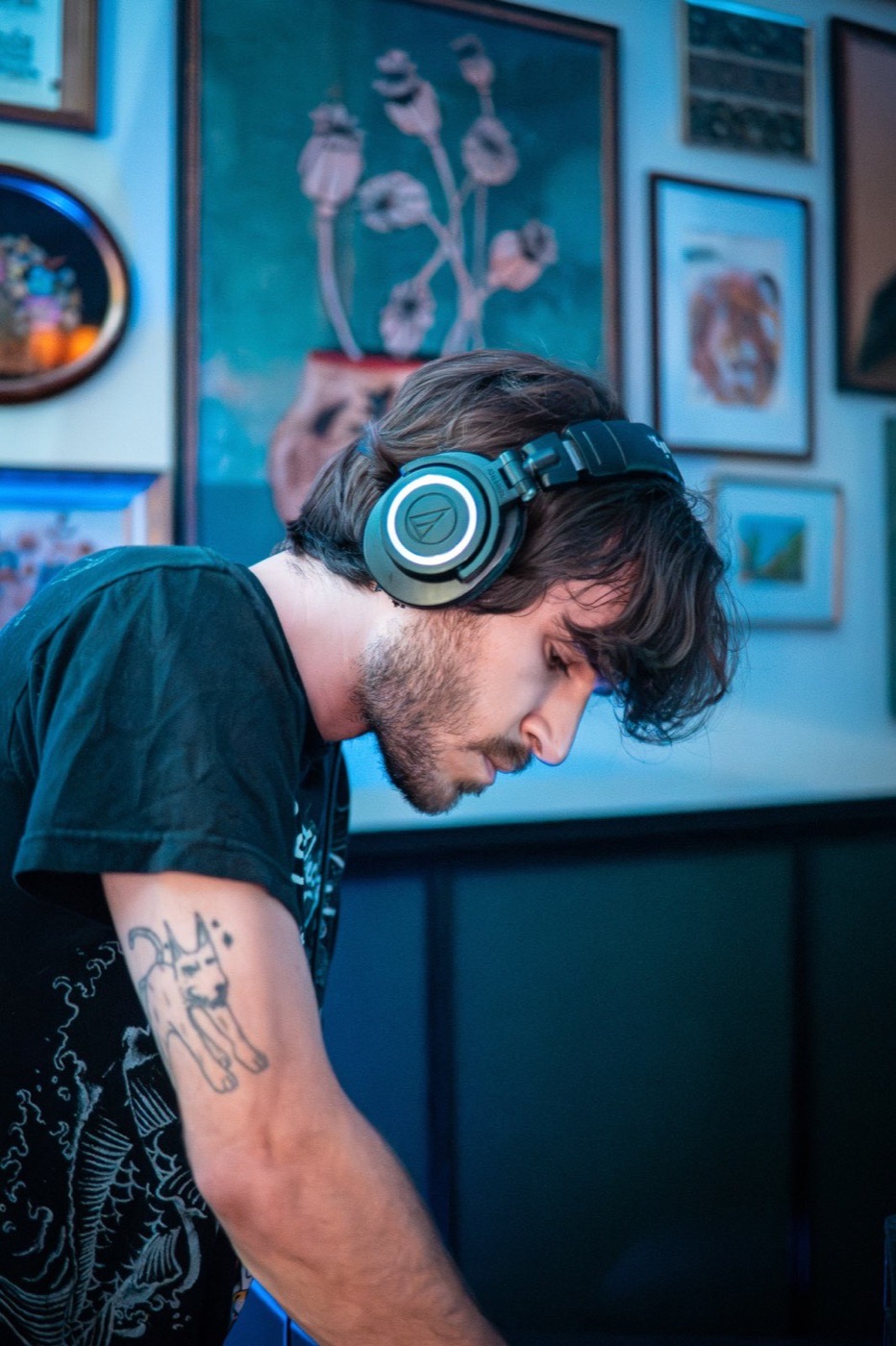 Portrait of a DJ wearing headphones in cool blue light