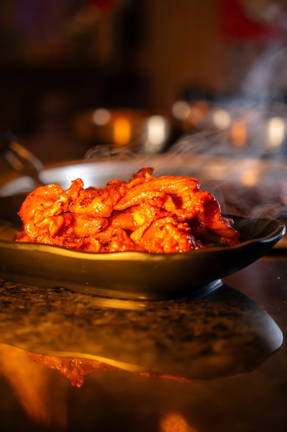 Close-up of steaming food plated in warm ambient light