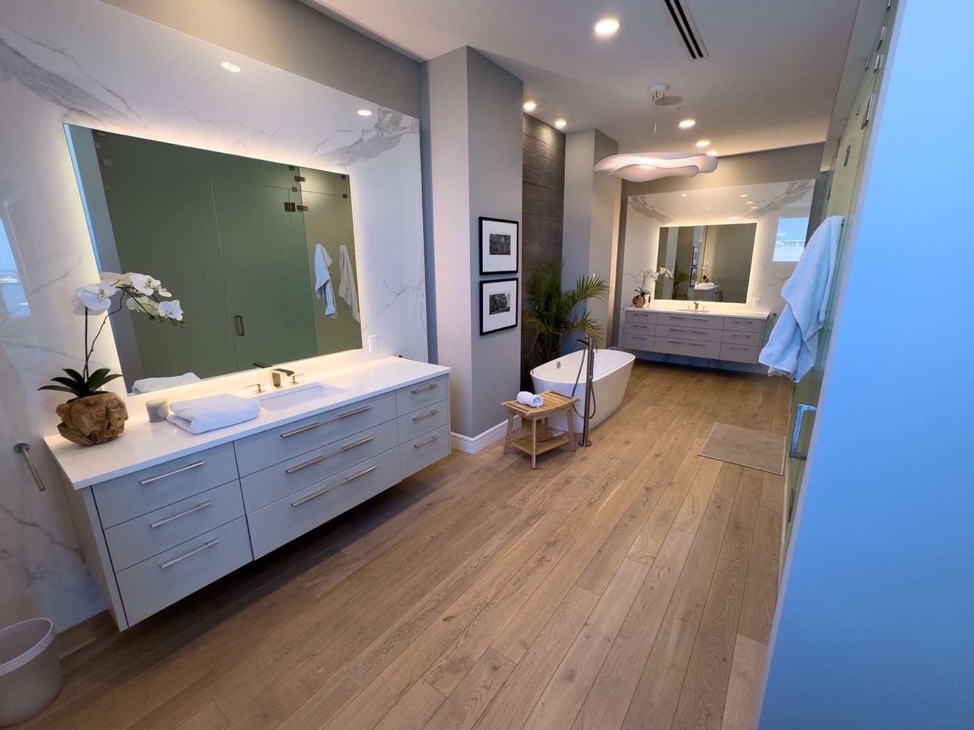 Modern bathroom interior with tub and warm wood flooring